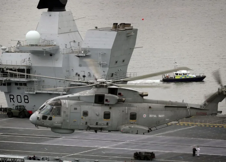 Un helicóptero AgustaWestland Merlin HM2 del Escuadrón Aéreo Naval 820 de la Royal Navy sobrevuela el portaaviones HMS Queen Elizabeth (R08) durante las pruebas de mar frente a la costa de Escocia, el 26 de junio de 2017. Imagen ilustrativa