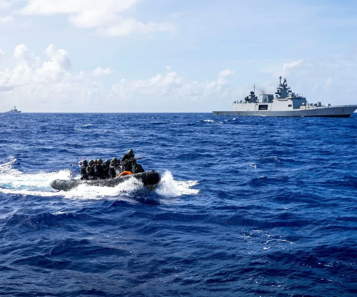 Un equipo de operaciones especiales a bordo de una lancha rápida semirrígida realiza maniobras tácticas en alta mar, con una fragata de sigilo clase Shivalik, en el marco de Malabar 2025